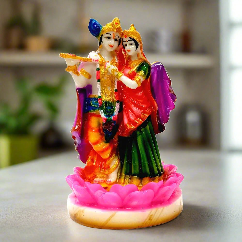 A beautiful marble dust Radha Krishna idol standing on a lotus flower.