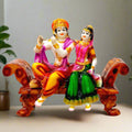 A marble dust Radha Krishna idol sitting beautifully on a throne.