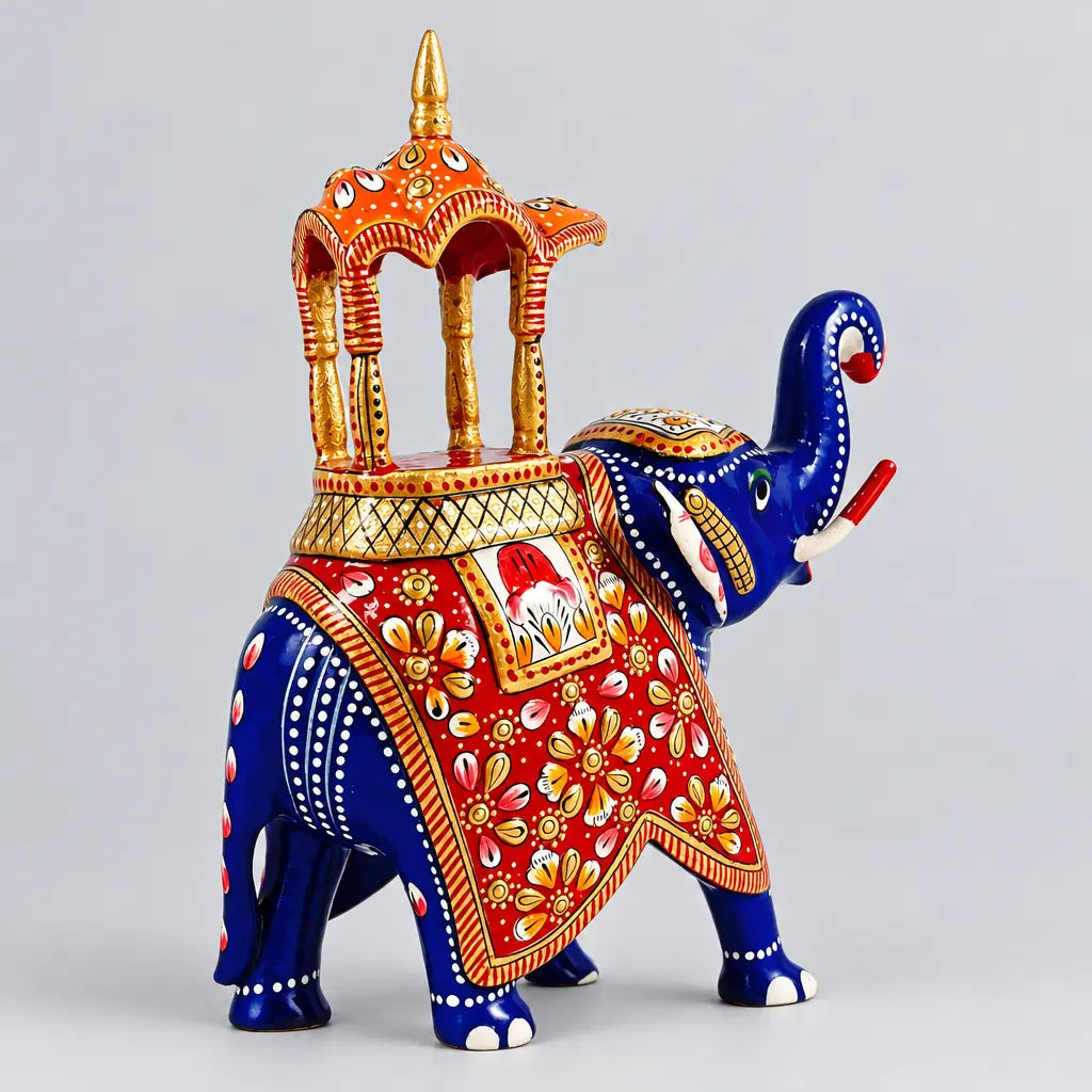 Rear angled view of a blue Meenakari Ambabari elephant showing its tail, red floral decoration and ornate orange-gold canopy.