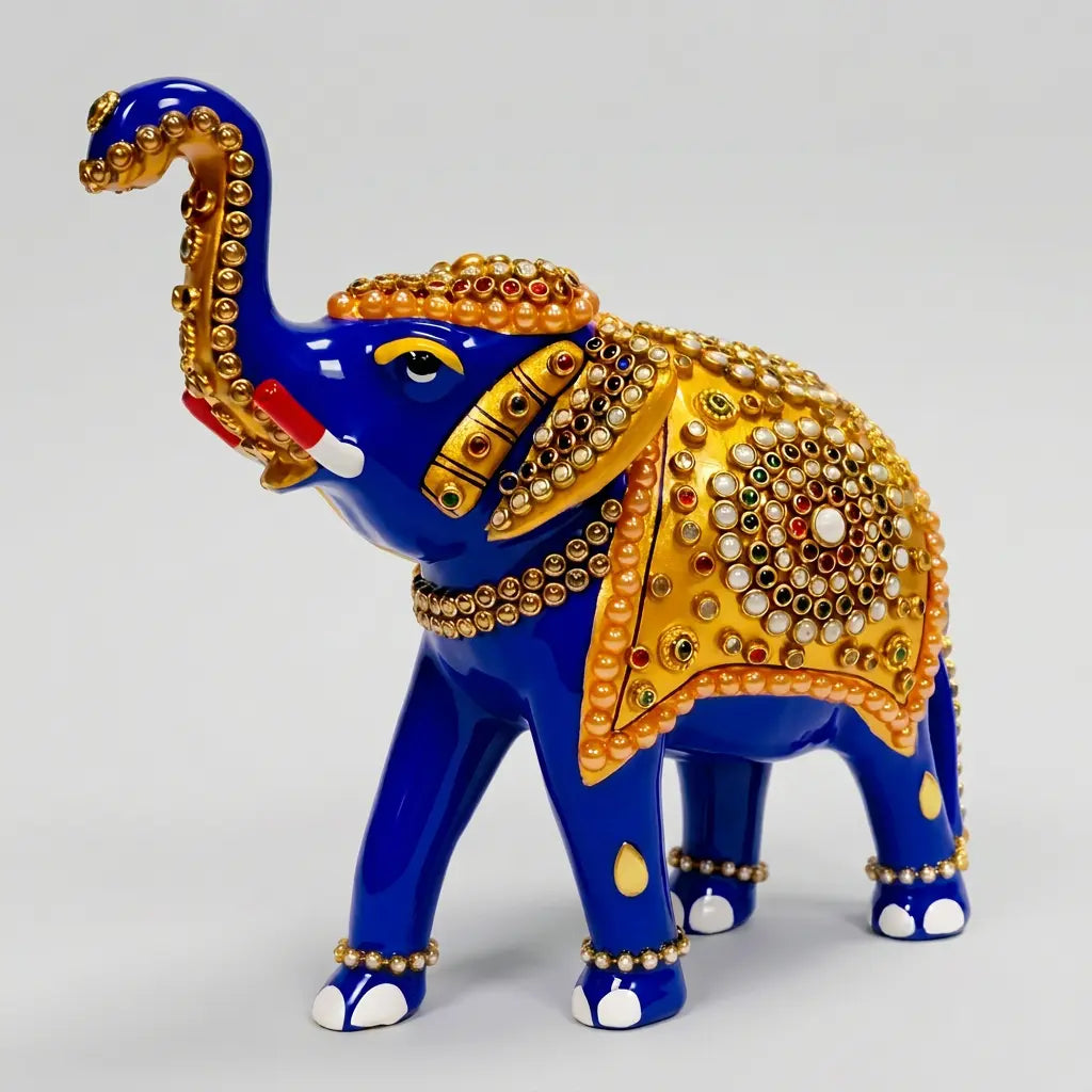 Meenakari elephant statue with a raised trunk and golden saddle decorated with multicolor stones, shown against a light grey background