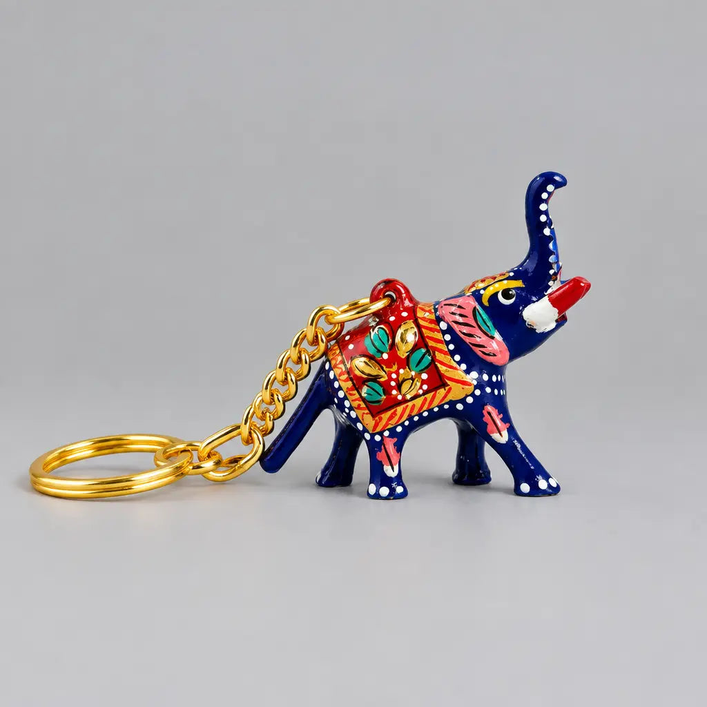 Blue Meenakari elephant keychain with a raised trunk, red floral saddle and gold-tone chain extending to the left