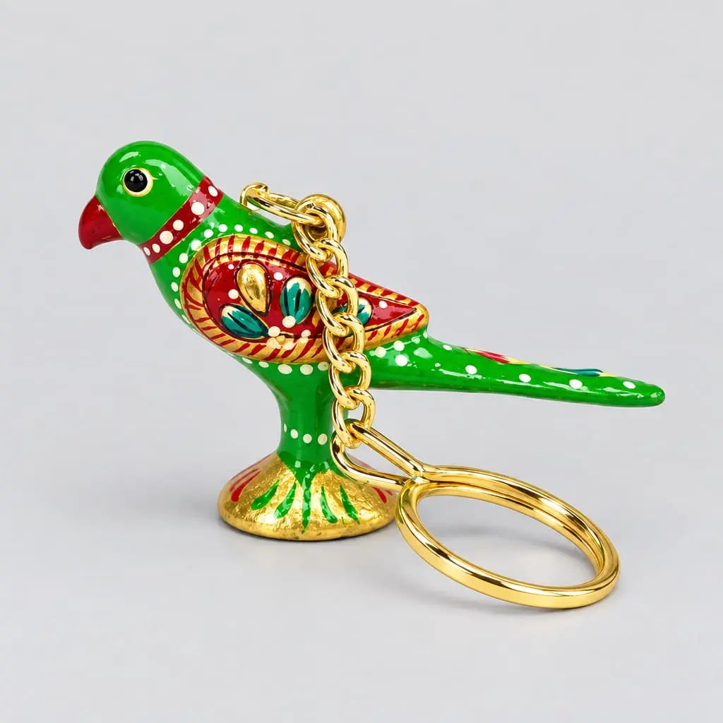 Side view of a green Meenakari parrot keychain with a decorated red wing and gold-tone chain and ring resting in front
