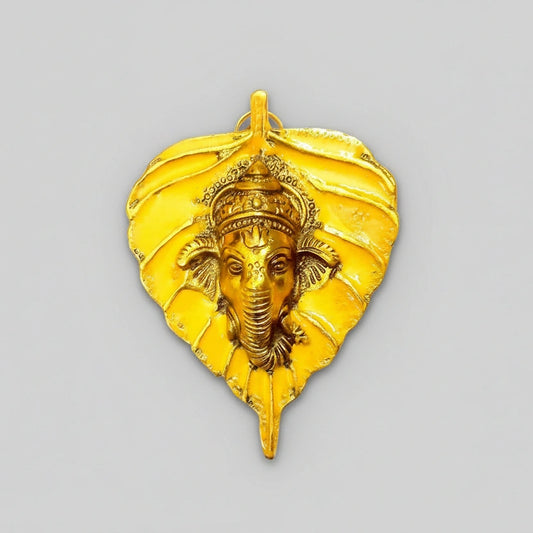 Vibrant metal leaf-shaped Ganesha wall decor with hand-painted enamel and golden polish.