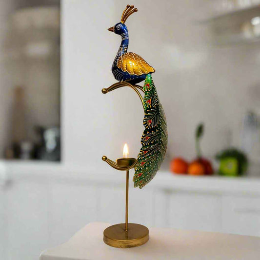 Decorative peacock candle holder on a stand with a lit candle.