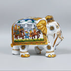 Close-up of hand-painted gold detailing on the trunk, ears, and nails of a white wooden elephant.