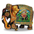 Left-facing Mughal miniature painted wooden elephant idol with a royal howdah scene, floral decoration and golden ears