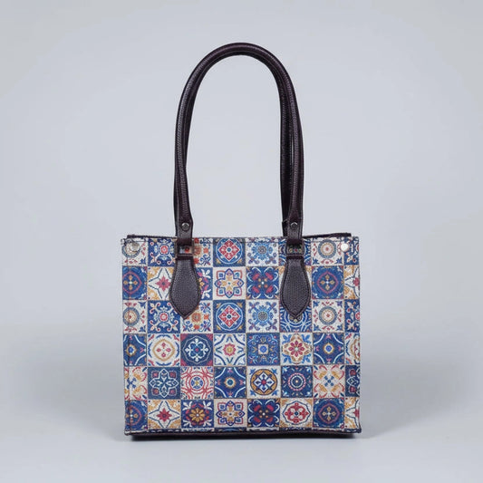 Front view of a Patola handbag featuring vibrant traditional patterns and brown synthetic PU leather handles.