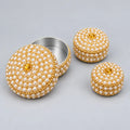 Three pearl-style bead lac kumkum boxes with golden detailing, showing the largest box open with its metal interior and decorated lid.