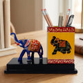 Wood and metal pen stand with a square holder and a Meenakari painted elephant with a raised trunk