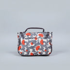 Close-up of the reinforced PU leather top handle and floral fabric texture