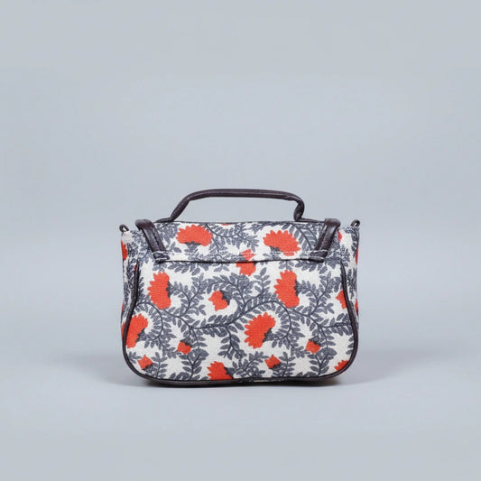 Close-up of the reinforced PU leather top handle and floral fabric texture