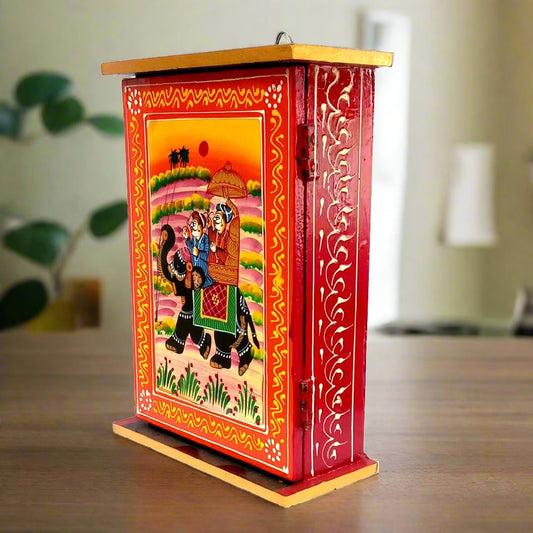 A wooden key organizer with 6 hooks, featuring a beautiful Raja Savari (Ambari Elephant) hand painting.