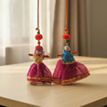 Handcrafted Rajasthani Couple Puppet Doll Hanging Set of 2 with Magenta Lehenga, Gold Border, Red Pom Poms and Wooden Beads