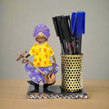  A Rajasthani-style metal pen stand featuring a cute musician playing a guitar.