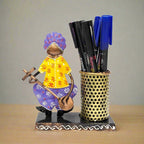  A Rajasthani-style metal pen stand featuring a cute musician playing a guitar.