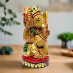 A round wooden Ganesha showpiece, decorated with beautiful multi-color hand painting.