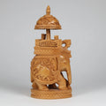 Detailed wood carving showcasing a Mahavat driver and two Kings seated in an ornamental palanquin.