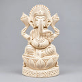 Front view of a Shreeparni wood Ganesha idol seated on a carved lotus base with a detailed crown and four arms