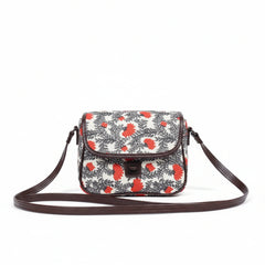 Front view of a small floral print sling bag with button closure and top handle