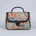 Front view of a small floral print ethnic crossbody bag with button closure.