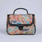 Front view of a small floral print ethnic crossbody bag with button closure.