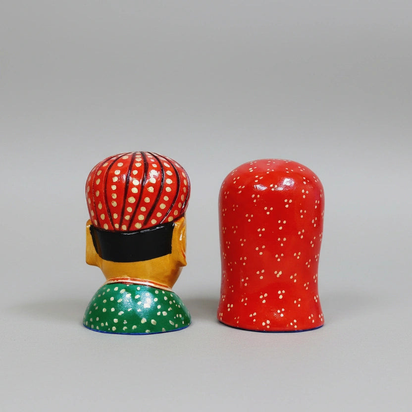Handcrafted wooden figurine showing traditional Rajasthani attire and jewelry details.