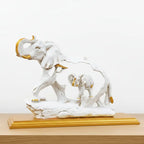 Close-up of raised trunk and golden tusk detail on white resin elephant showpiece