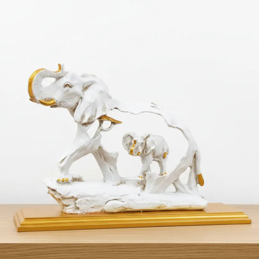 Close-up of raised trunk and golden tusk detail on white resin elephant showpiece