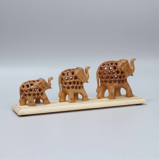 Hand-carved Kadamb wood elephant family on a bridge base, featuring intricate undercut jali work where a smaller elephant is carved inside the larger one.