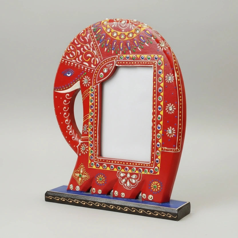 Close-up of a handcrafted red wooden elephant frame featuring intricate colorful paintwork and a sturdy tabletop base, perfect for bohemian home decor.