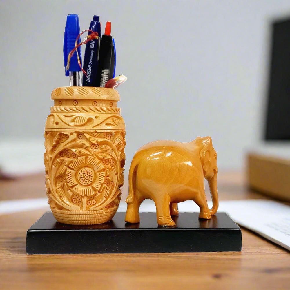 Unique Rajasthani pen stand with elephant figurine on wooden platform.