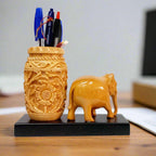 Unique Rajasthani pen stand with elephant figurine on wooden platform.