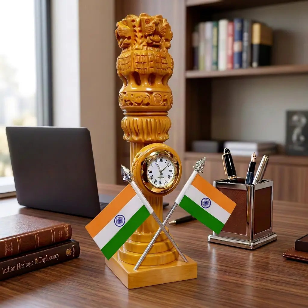 Wooden Ashok Pillar with clock and two crossed Indian flags on an office desk beside a laptop and pen stand