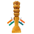 Rear view of a carved wooden Ashoka Pillar on a square base with two Indian flags against a white background
