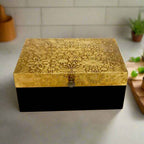 Showcasing fine craftsmanship, this antique-style wooden box has detailed brass work on the top, making it a stylish and functional accent piece.
