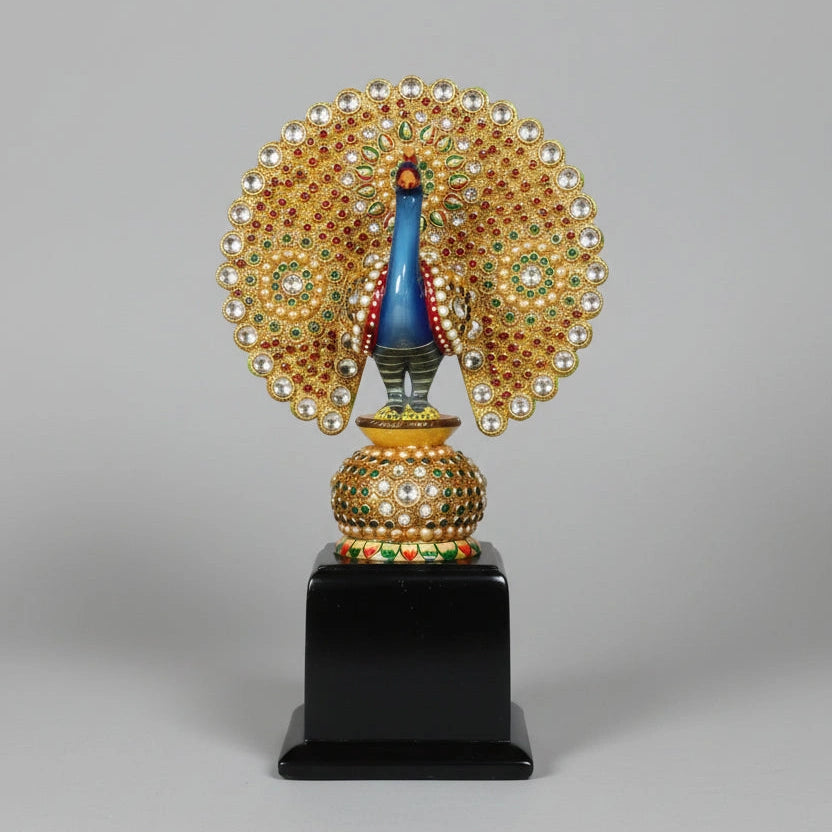 A handcrafted wooden dancing peacock memento intricately studded with shimmering stones on a polished base.