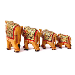 A wooden elephant family sculpture with their trunks up, showcasing beautiful artistry.