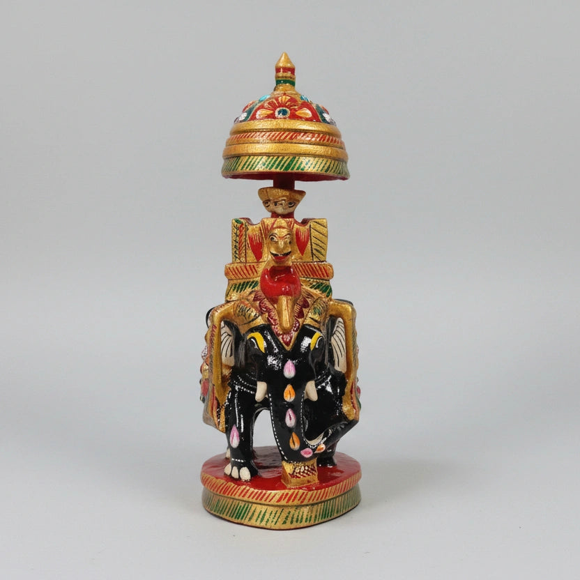 Top view of a wooden elephant featuring a golden umbrella with multicolor paint.