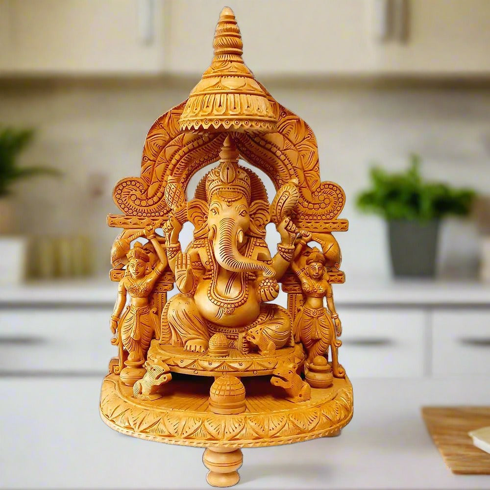 A wooden Ganesha idol with Riddhi Siddhi, sitting in a beautifully carved pavilion.