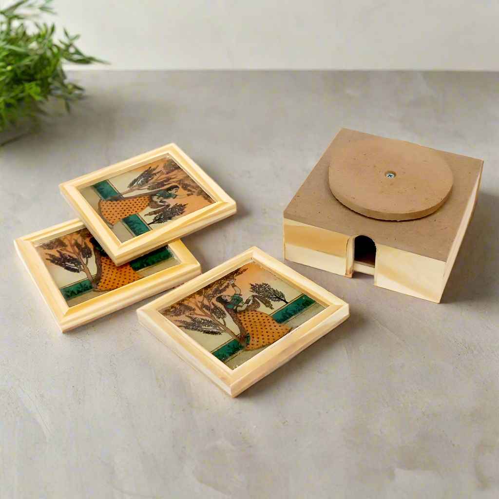 Square glass coasters with miniature artwork of lady, elephant, and Taj Mahal, set in a 360° rotating wooden holder.