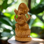 Angled view of wooden lotus Ganesh showing the curved trunk, carved jewellery and layered lotus petals
