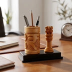 Wooden Indian Rupee pen stand holding pens and a pencil beside an Ashoka Pillar on a black base