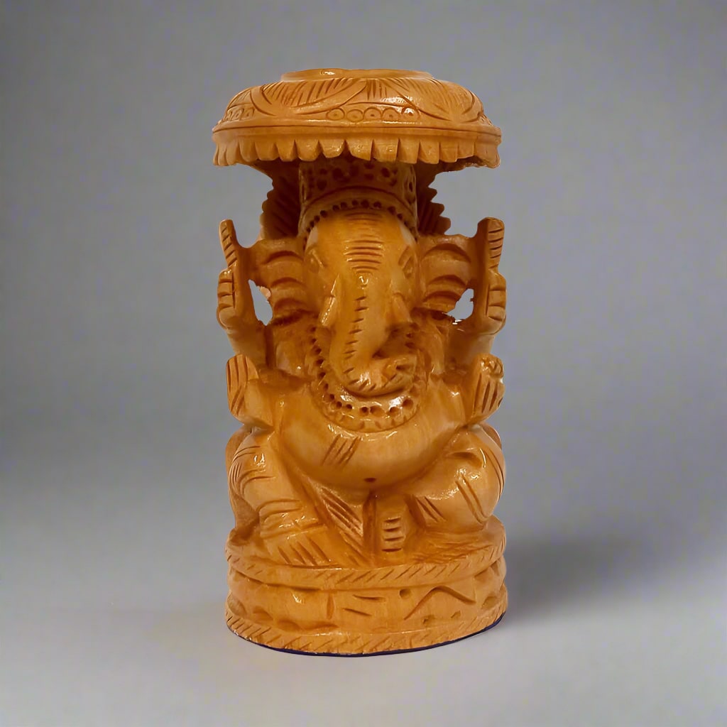 Hand-carved wooden Ganesha idol with a distinctive round shape and umbrella on top, showcasing intricate artisan detailing