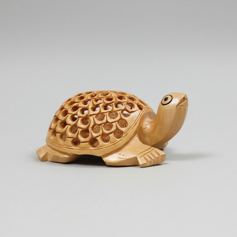 Wooden tortoise statue showing the intricate lattice undercut carving design on its back.