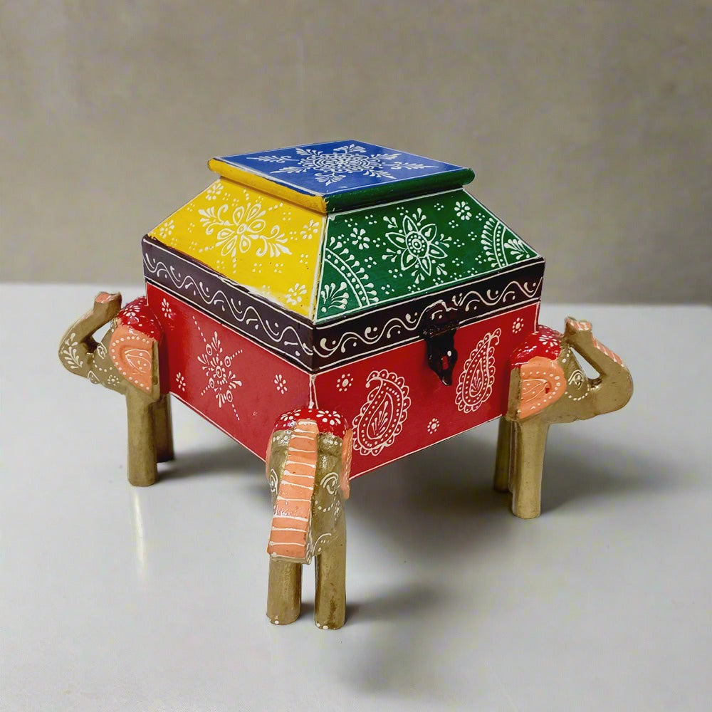 Artisan-crafted wooden jewelry box adorned with four hand-painted elephants, combining function and traditional art.