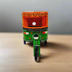 Artisanal wooden auto rickshaw showpiece showcasing fine hand painting and vibrant colors for elegant decoration.

