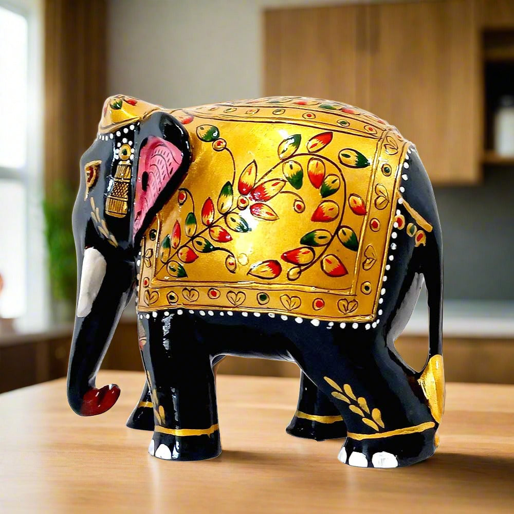 A black and golden elephant with intricate floral emboss painting, an amazing piece for home decor.