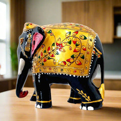 A black and golden elephant with intricate floral emboss painting, an amazing piece for home decor.