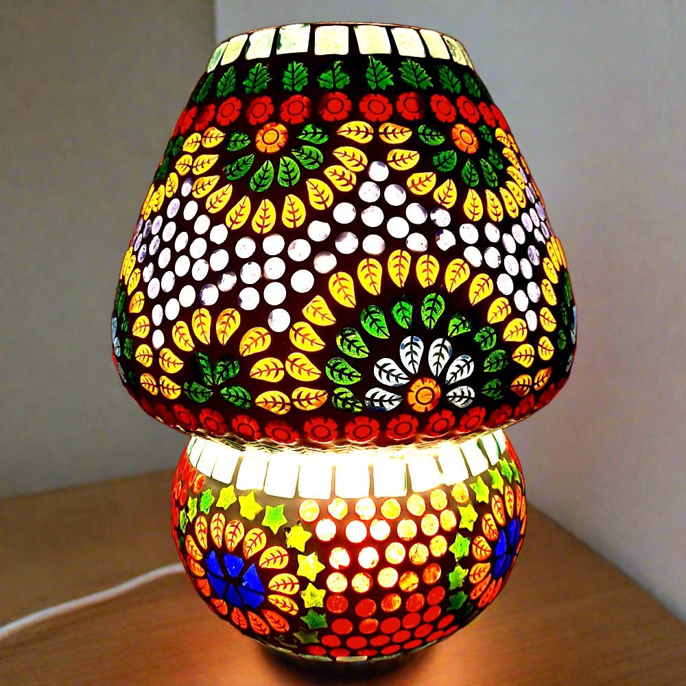 Colorful mosaic pattern glass lamp casting vibrant shadows in the dark.