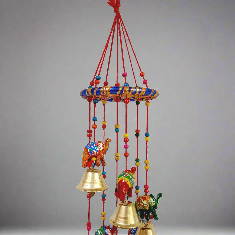 A colorful papermache toran with elephant, golden bell, beads, and thread work.